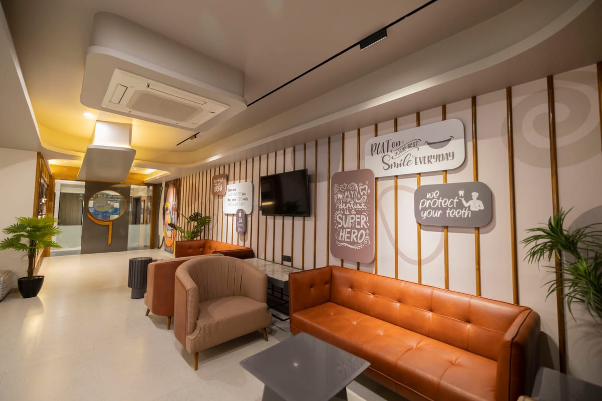 The children's waiting area, an orange sofa facing a wall of playful dental illustrations