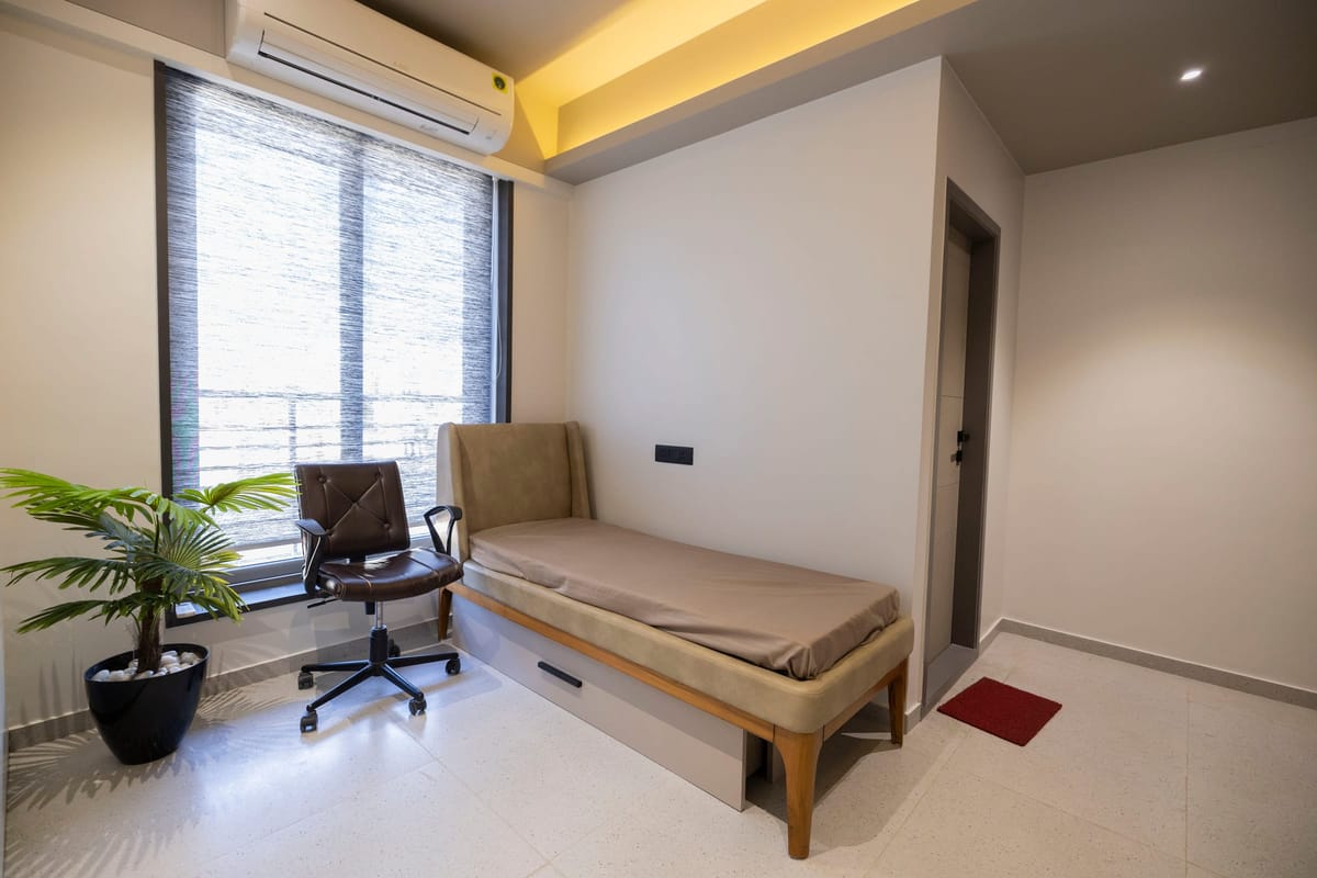 A recovery room with a daybed beside a window