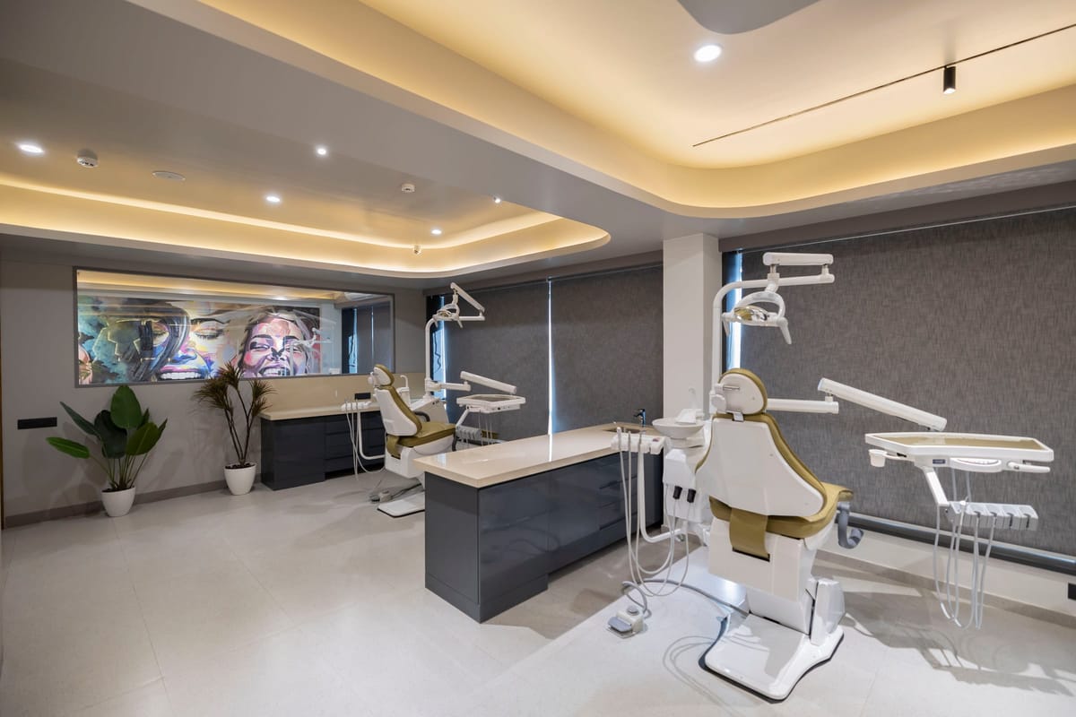 The Dental House નો સારવાર ખંડ — પાછળની દીવાલ પર ચિત્રકામ, દિવસના અજવાળામાં ખુરશી અને સાધનો